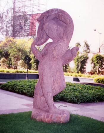 Dynamic pink marble Hanuman sculpture in devotional pose with detailed muscular definition and traditional iconography